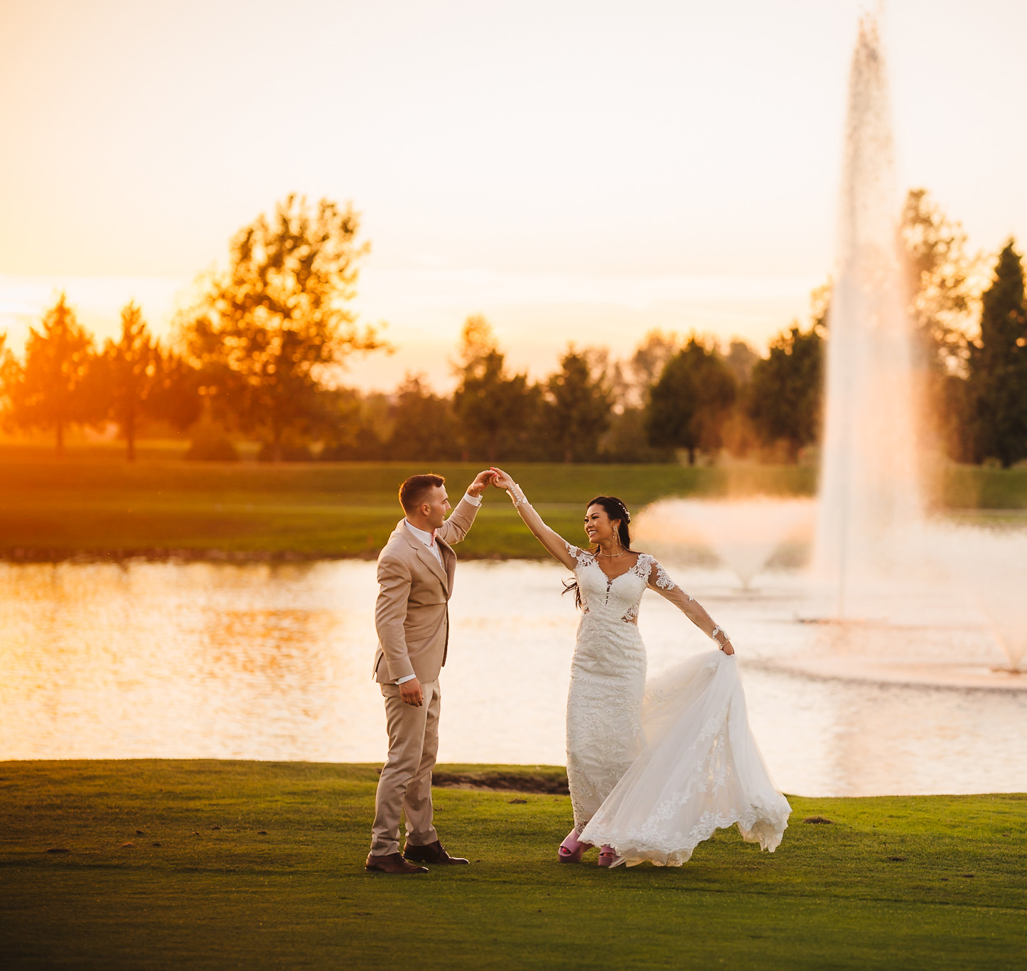 Bride and groom dancing near a water fountain