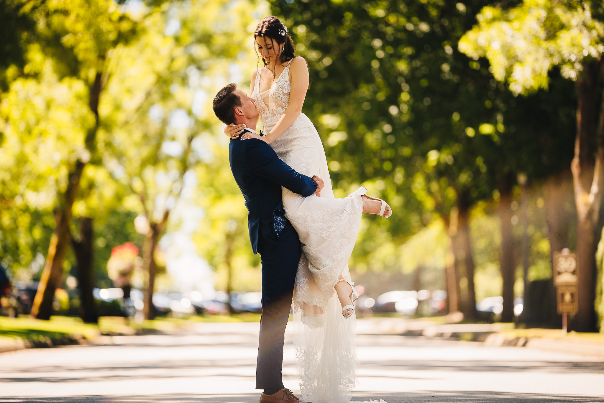 Groom lifting the bride surrounded by lush trees