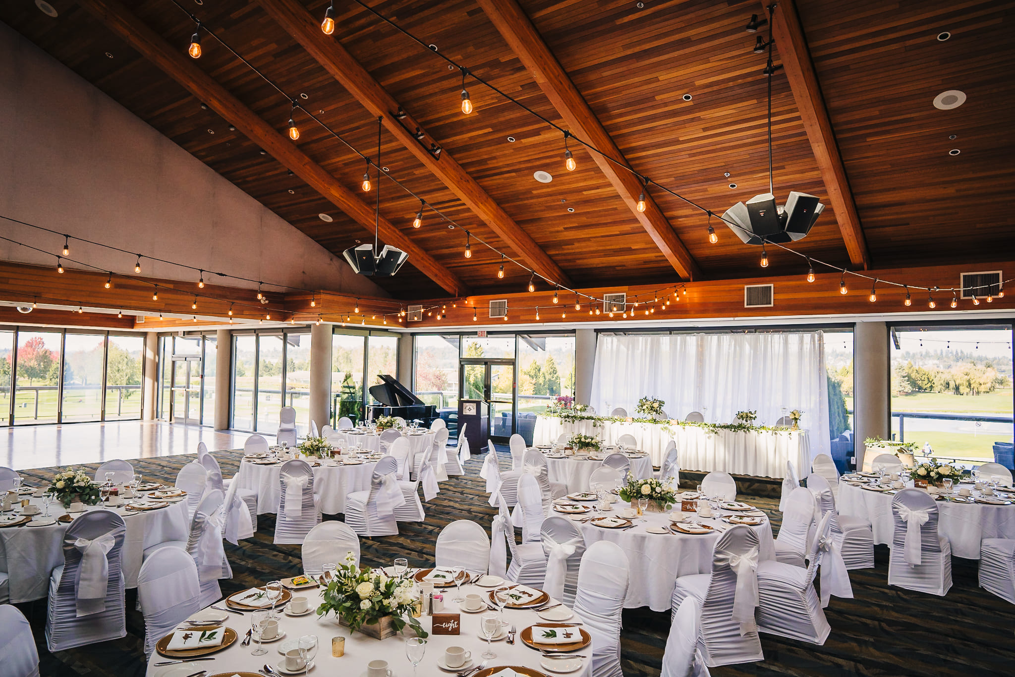 Ground view of Northview Golf's banquet hall with tables and chairs decorated in white