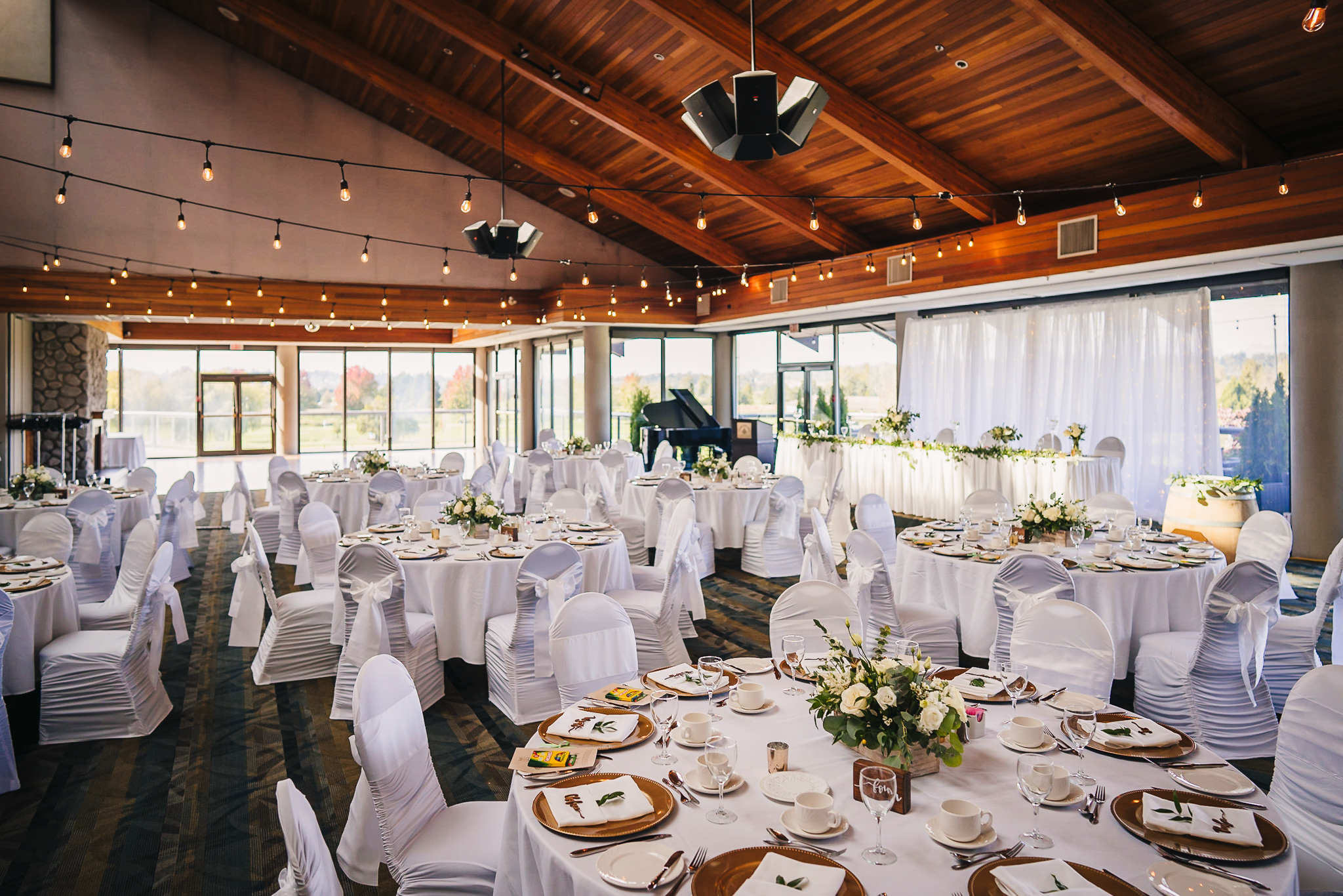 View inside the banquet hall with the tables and chairs decorated in white