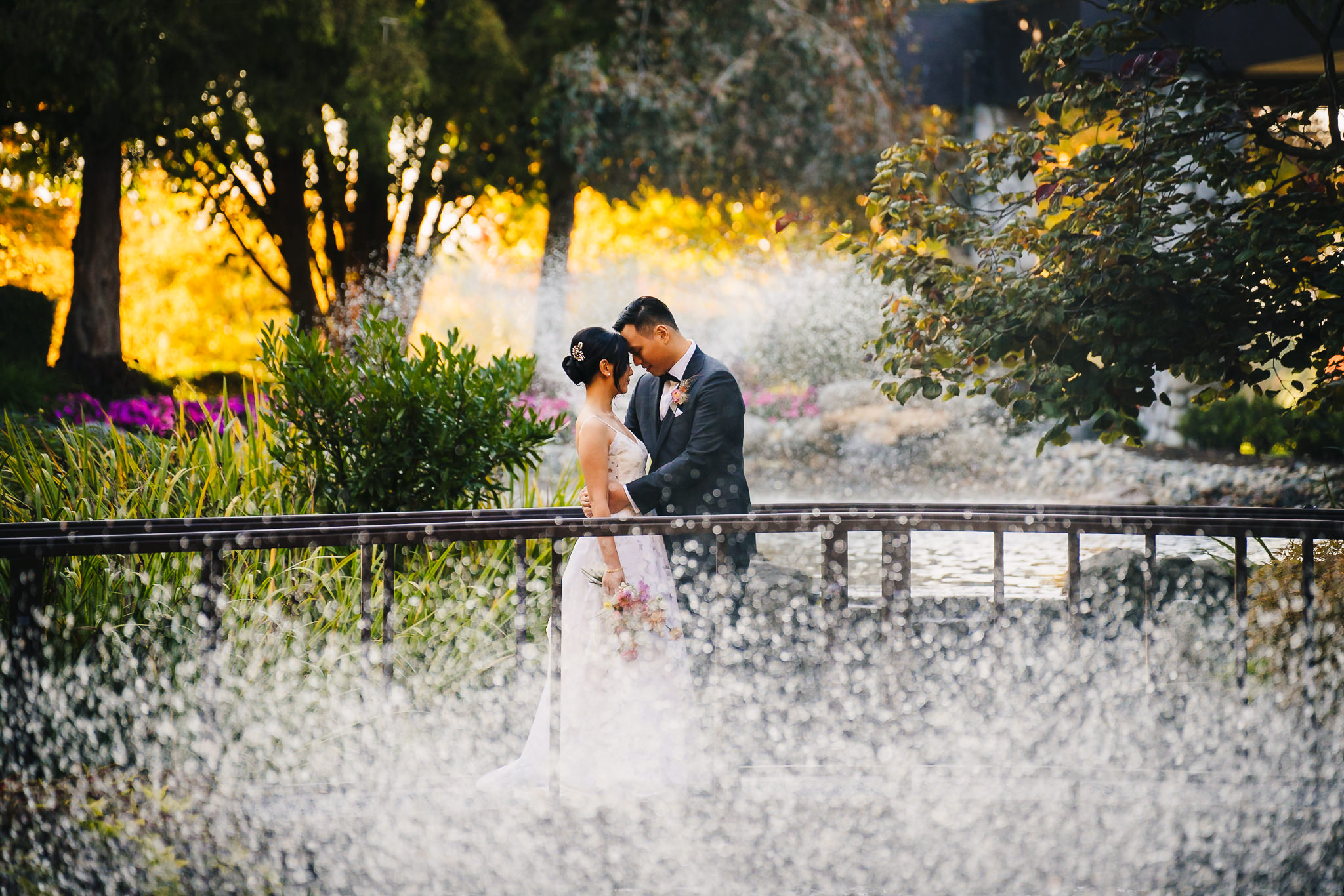 Bride and groom embracing each other on the bridge within the enchanted garden