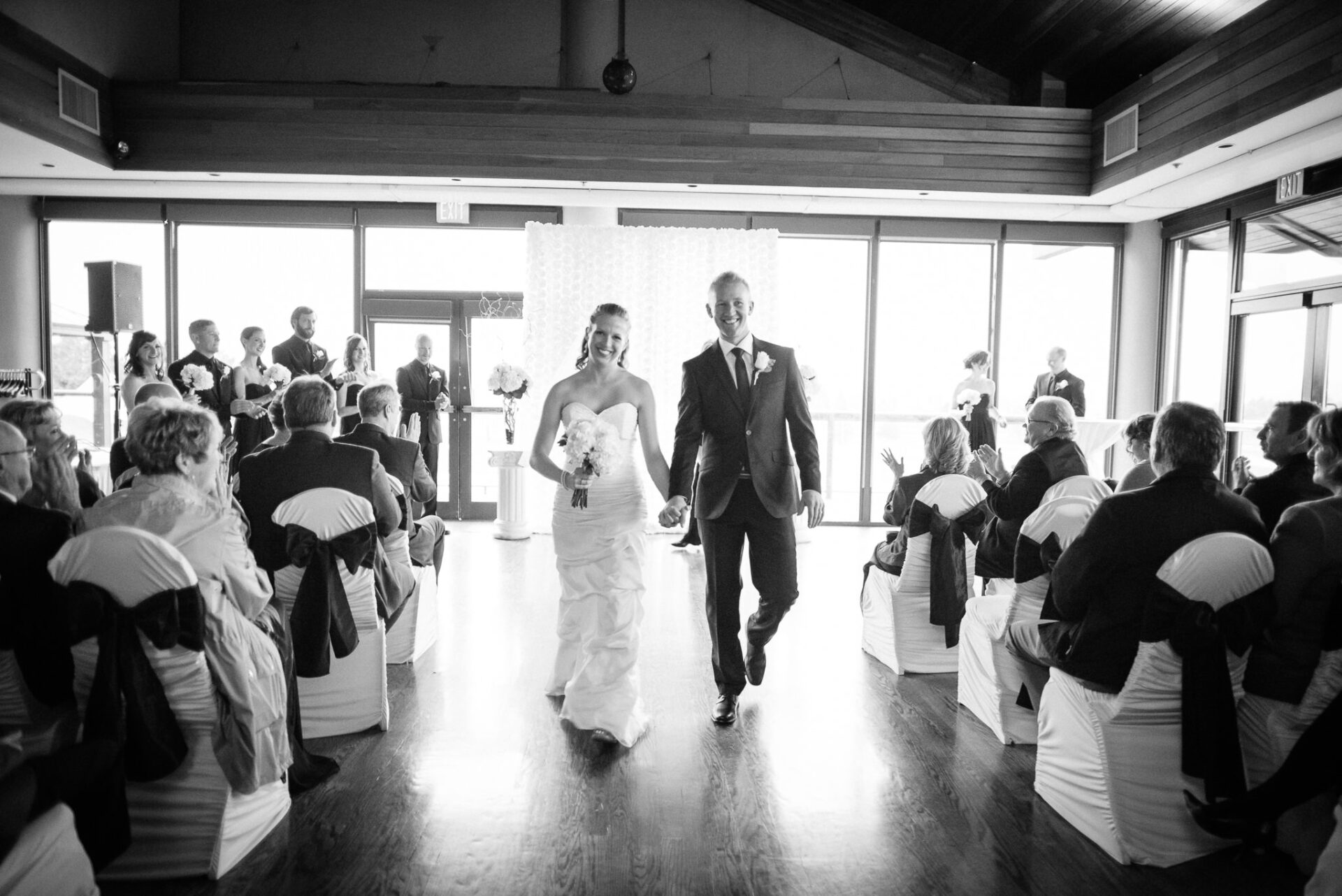 Bride and groom, holding hands and walking down the aisle