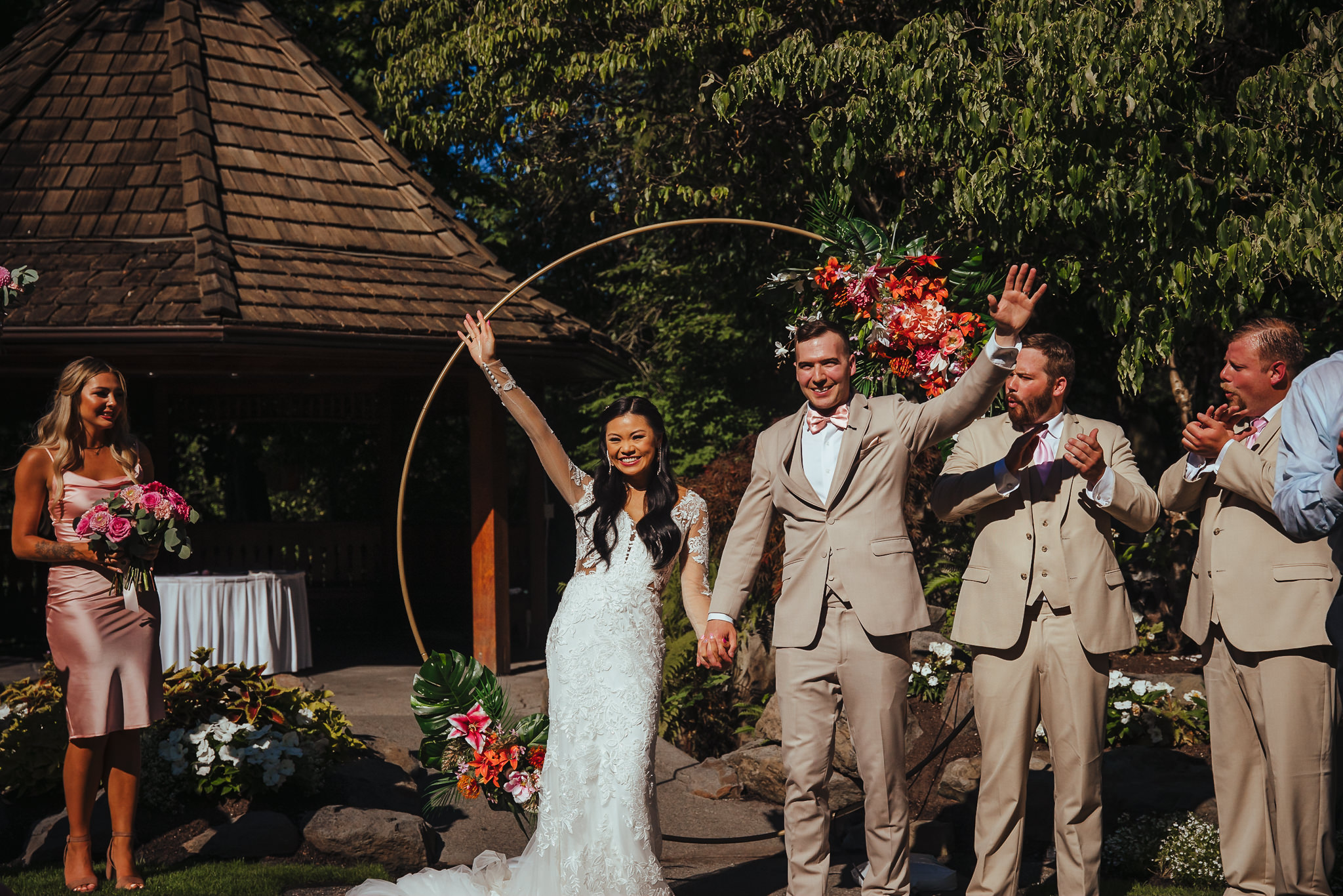 Bride and groom smiling and waving at the guests