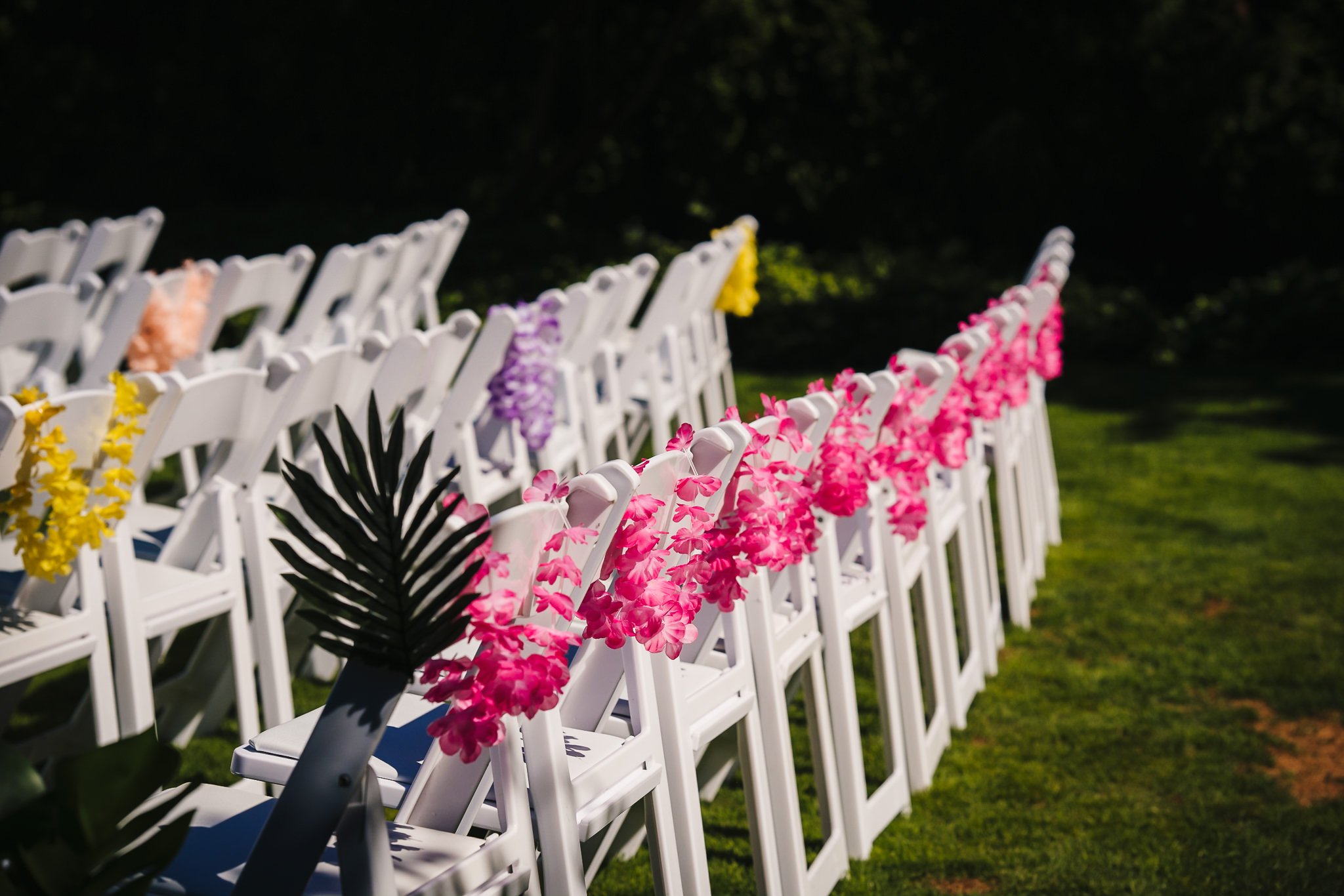 Close up of multiple rows of chairs decorated with colourful flowers