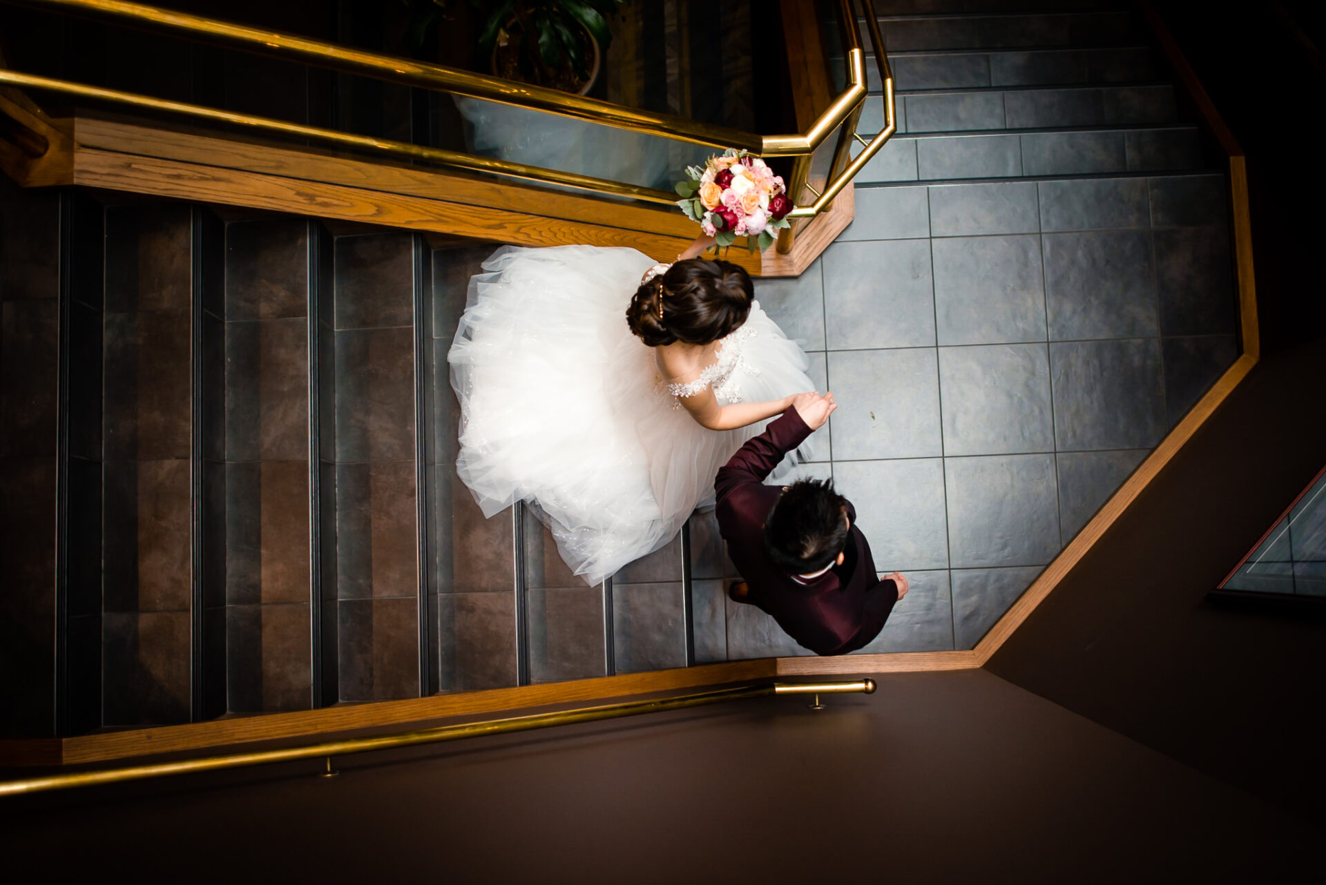 Aerial view of bride and groom walking down a set of stairs