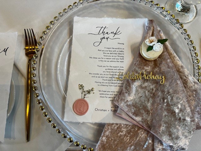 Close up of a plate with cutlery and a printed thank you message set on top