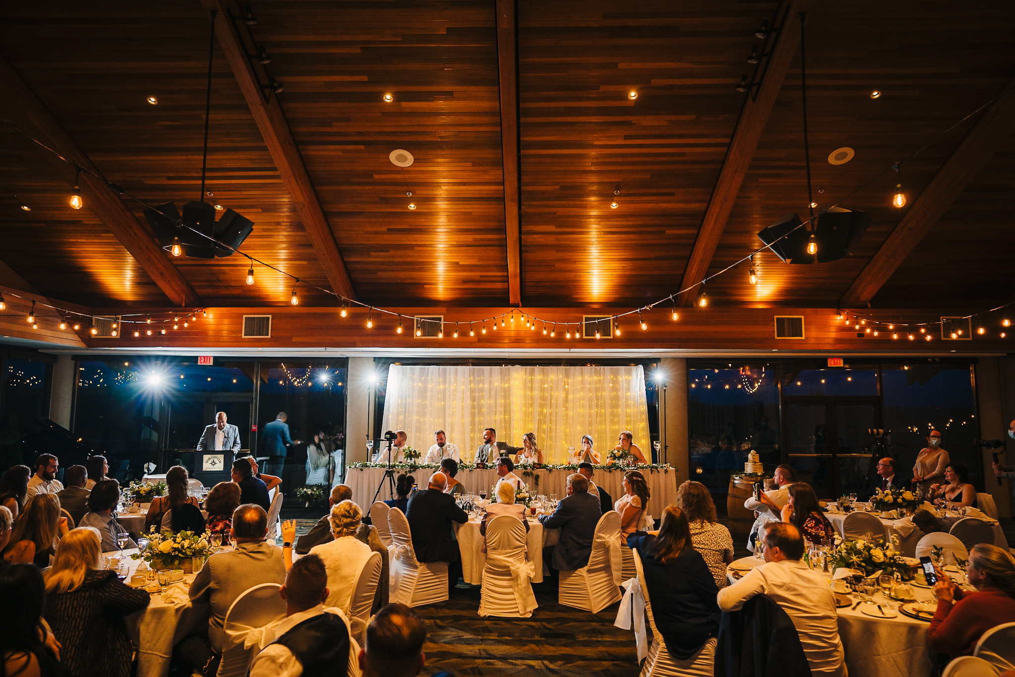 View of the wedding party, with a member of the groom's party sharing a speech