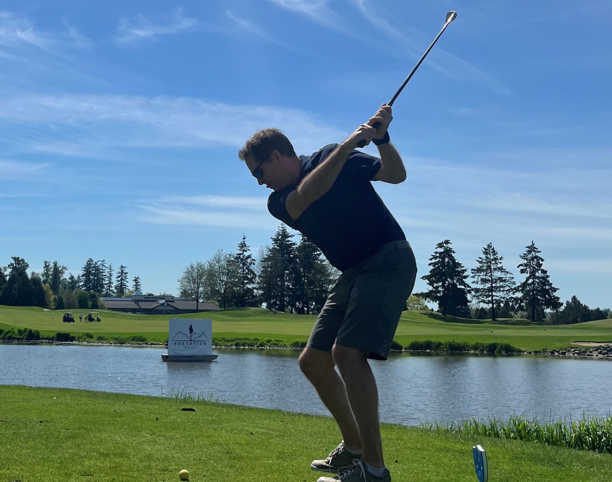 Male golfer in mid swing stance
