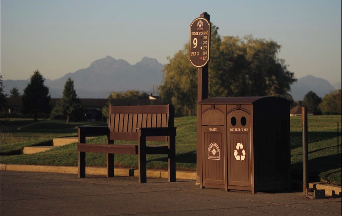 View of a bench and trash bins during dawn or dusk