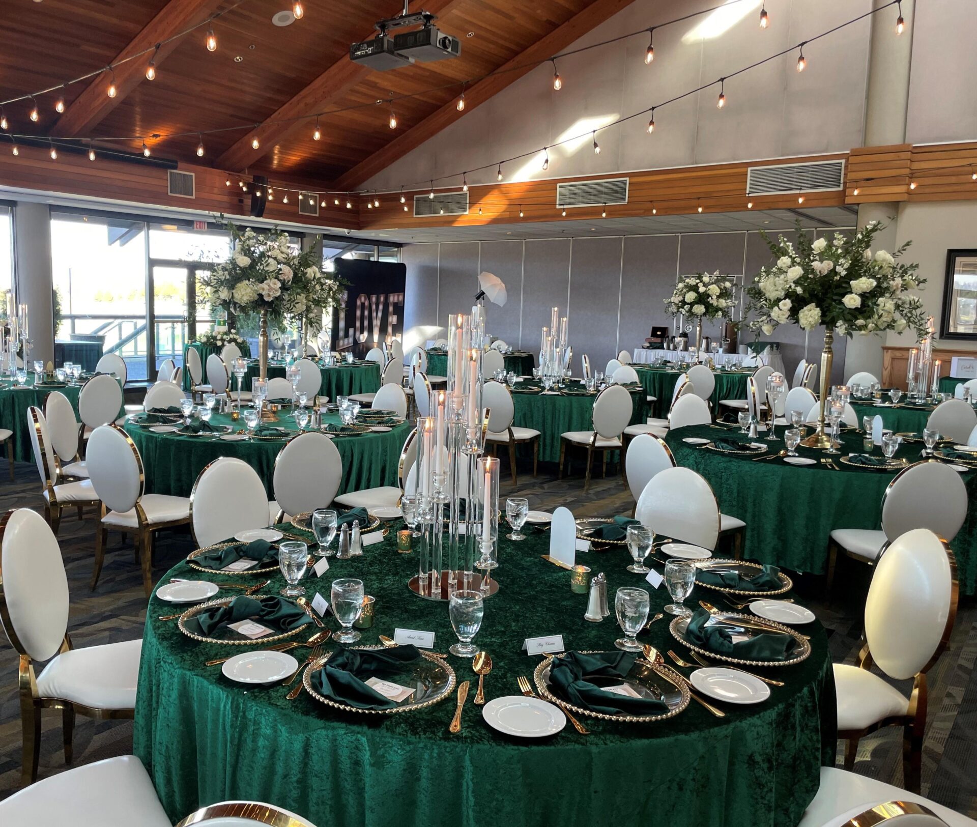 View of beautifully set tables and chairs decorated in white and green