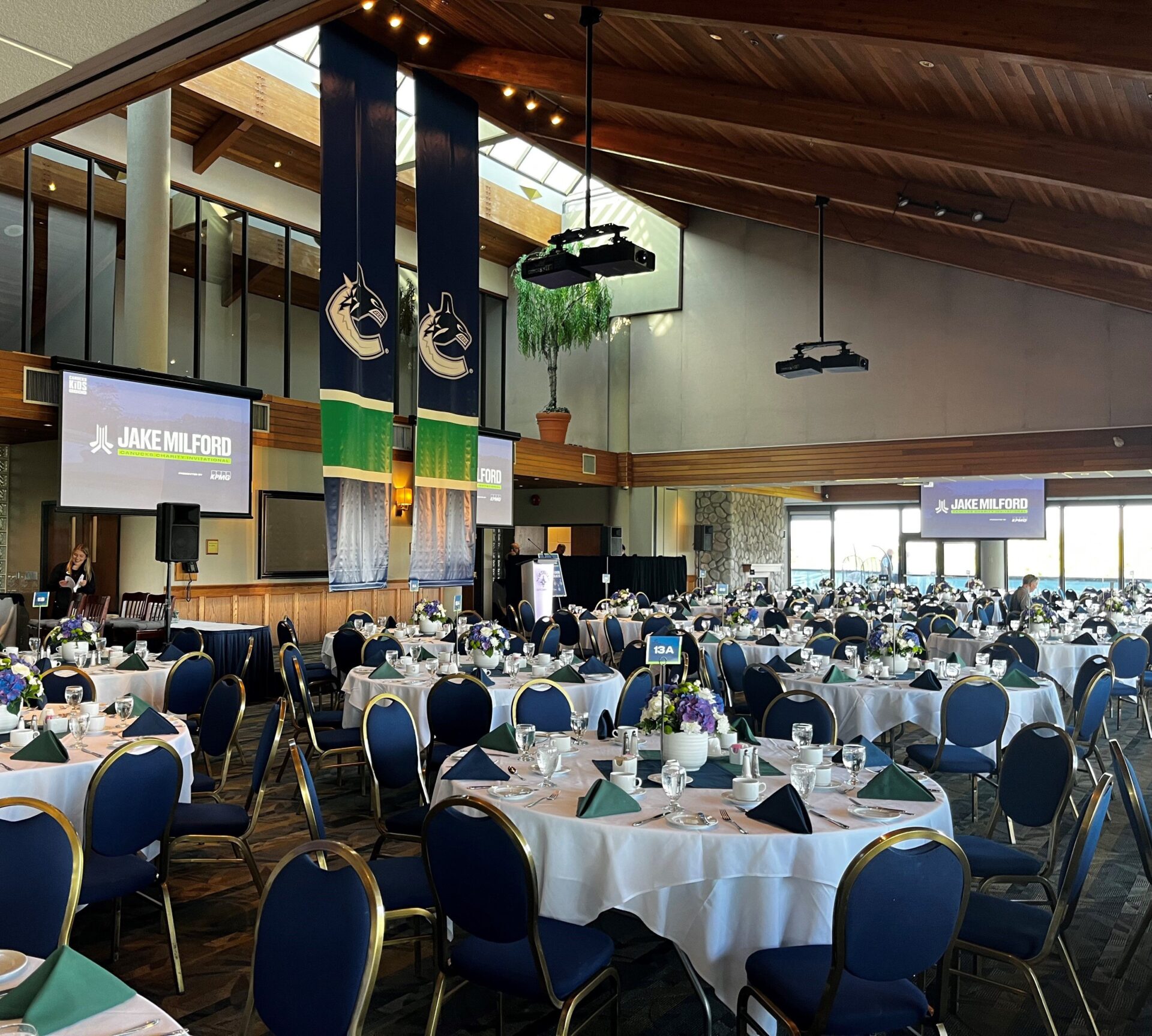 View of set tables and chairs, with Vancouver Canucks banner hanging from the ceiling